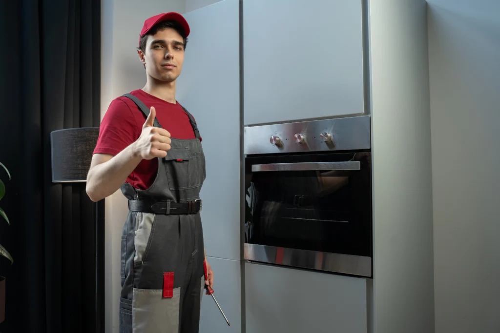 Skilled Repairman Fixes Electric Oven in Modern Kitchen During Daytime